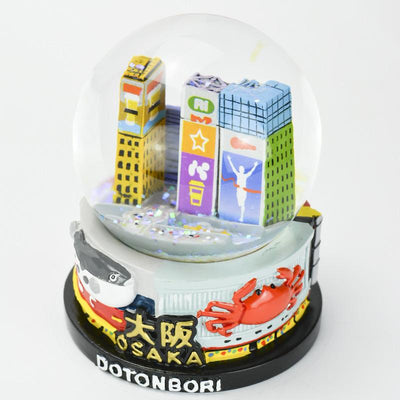 musubiオリジナルスノードーム  大阪ミナミを代表する街「道頓堀」がテーマです。 道頓堀川沿いのサイン看板と戎橋を訪れる多くの人々で遊び心満載な活気ある街を表現しました。台座は食い倒れの街名店のうまいもん看板を造形しました。